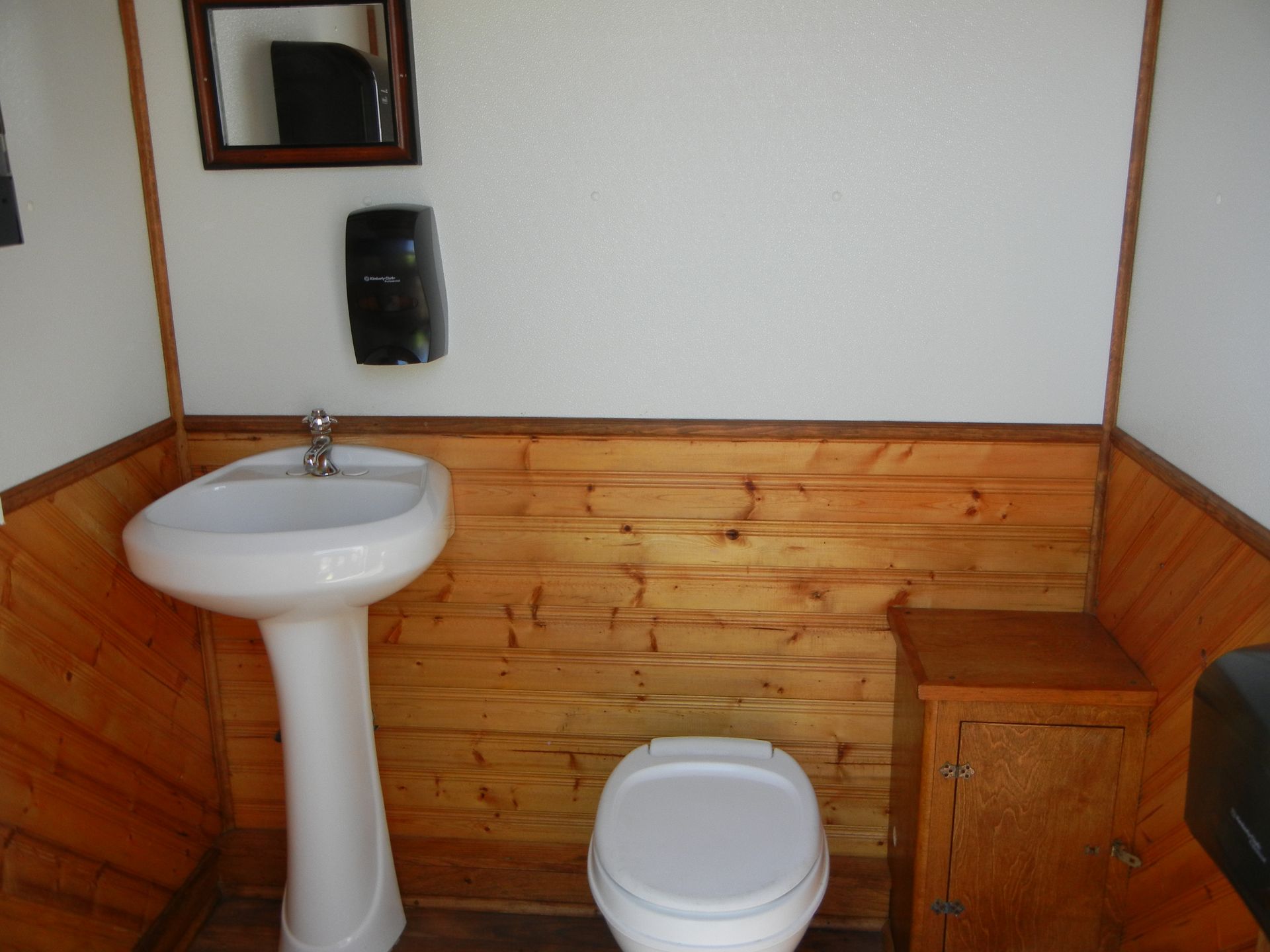 a bathroom with a toilet a sink and a mirror