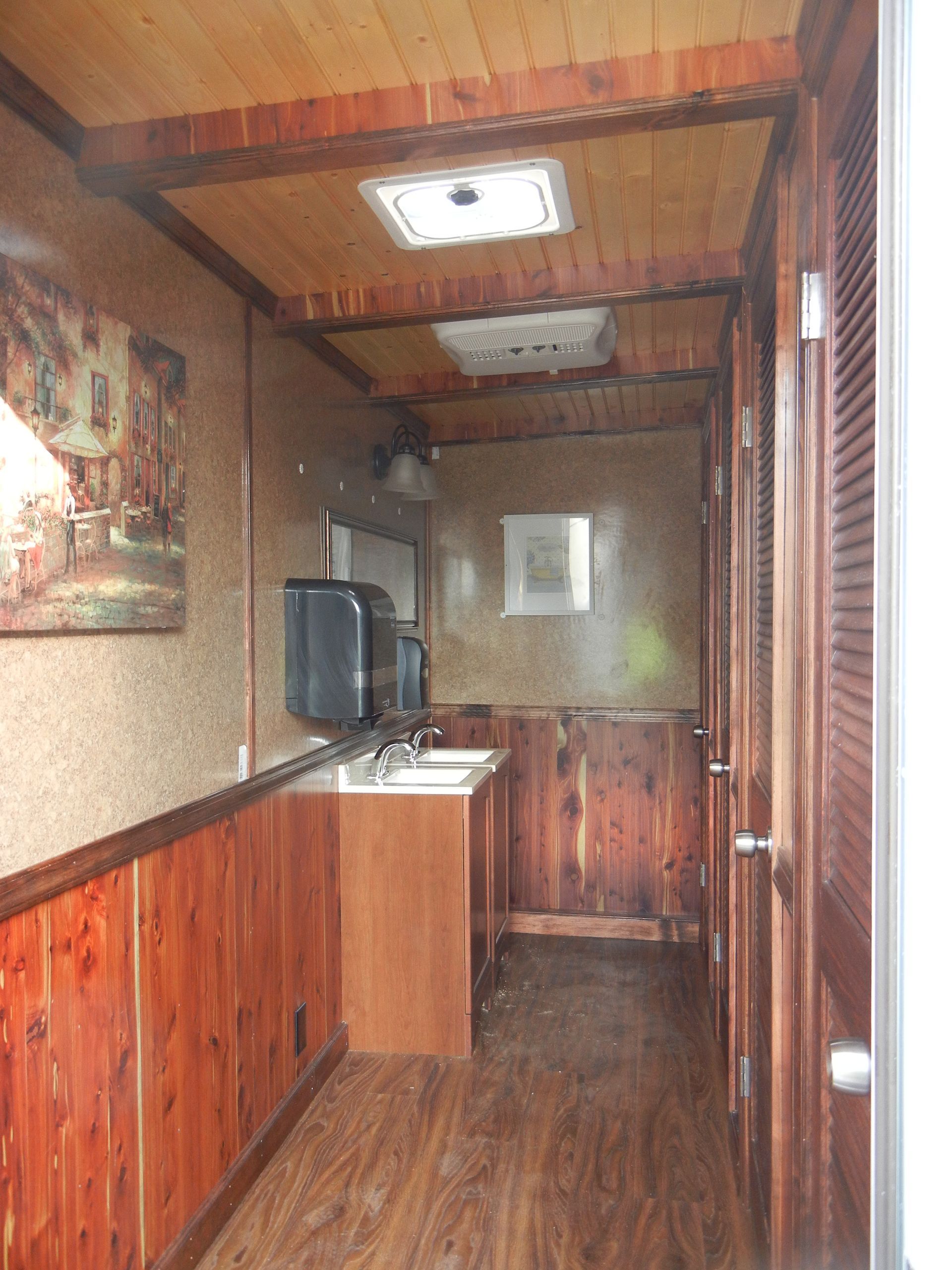 a long hallway with wooden cabinets and sinks