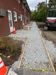 A walkway is being built in front of a brick building.