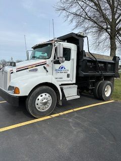 A white dump truck is parked in a parking lot.