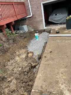 A car is parked in a garage next to a hole in the ground.