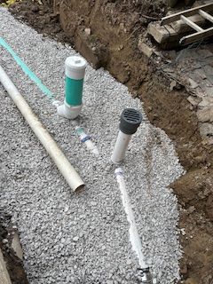 A bunch of pipes are sitting on top of a pile of gravel.