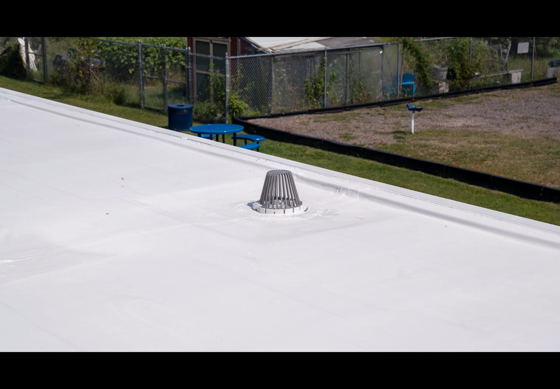 Small rooftop skylight with a metal frame on a white, snow-covered roof