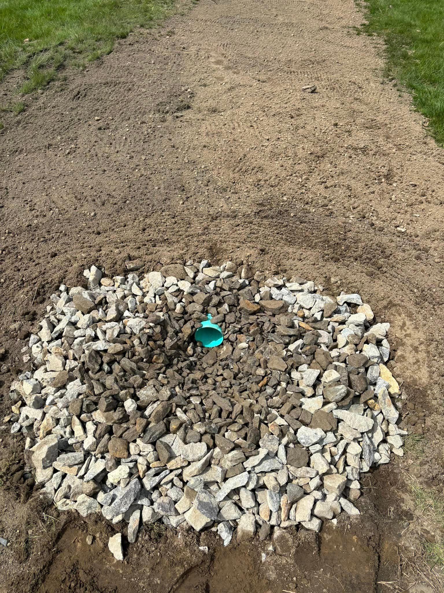 A gravel path with a small rock ring around a green marker in the foreground.