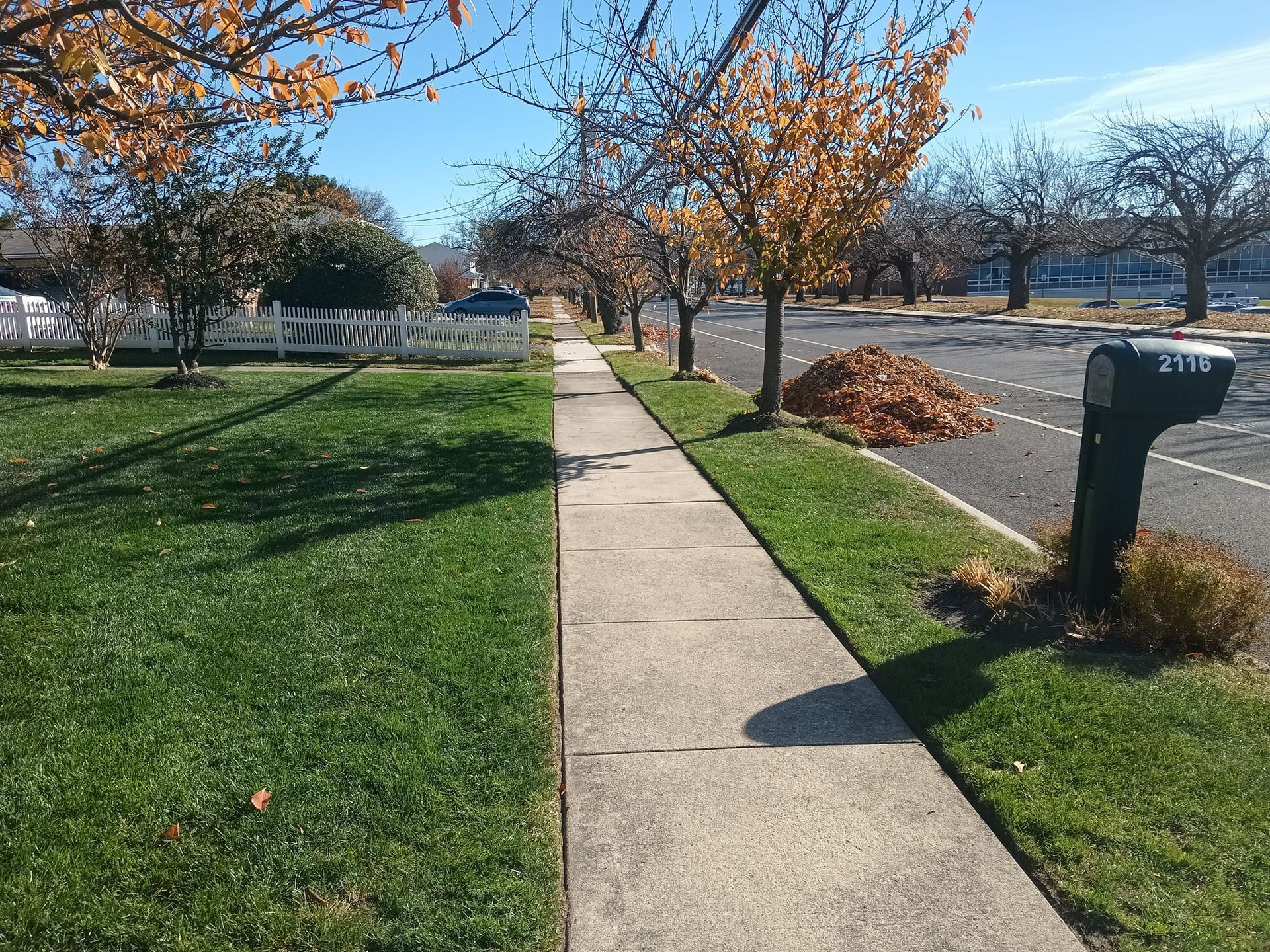 A sidewalk with a mailbox on the side of it
