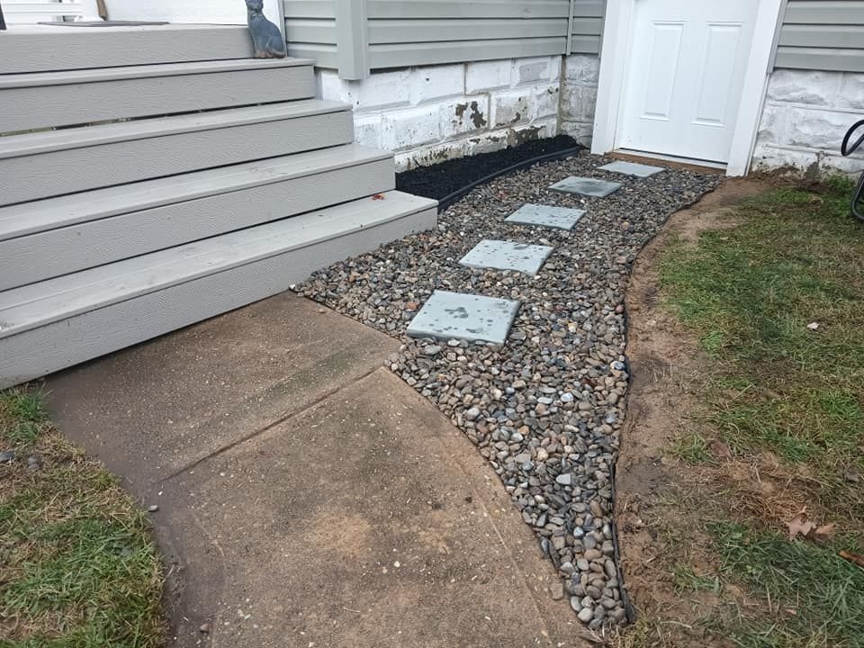 A walkway with stepping stones leading to the front door of a house.