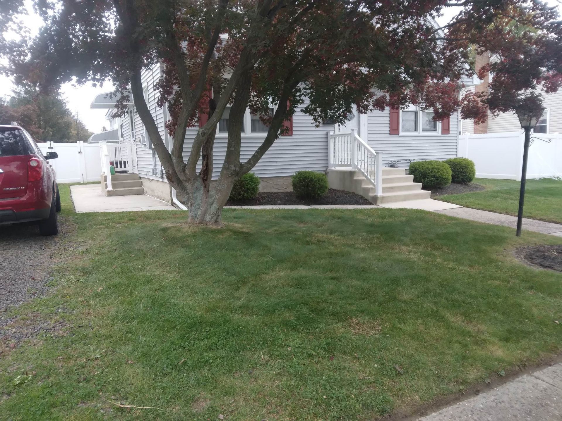 A red car is parked in front of a house