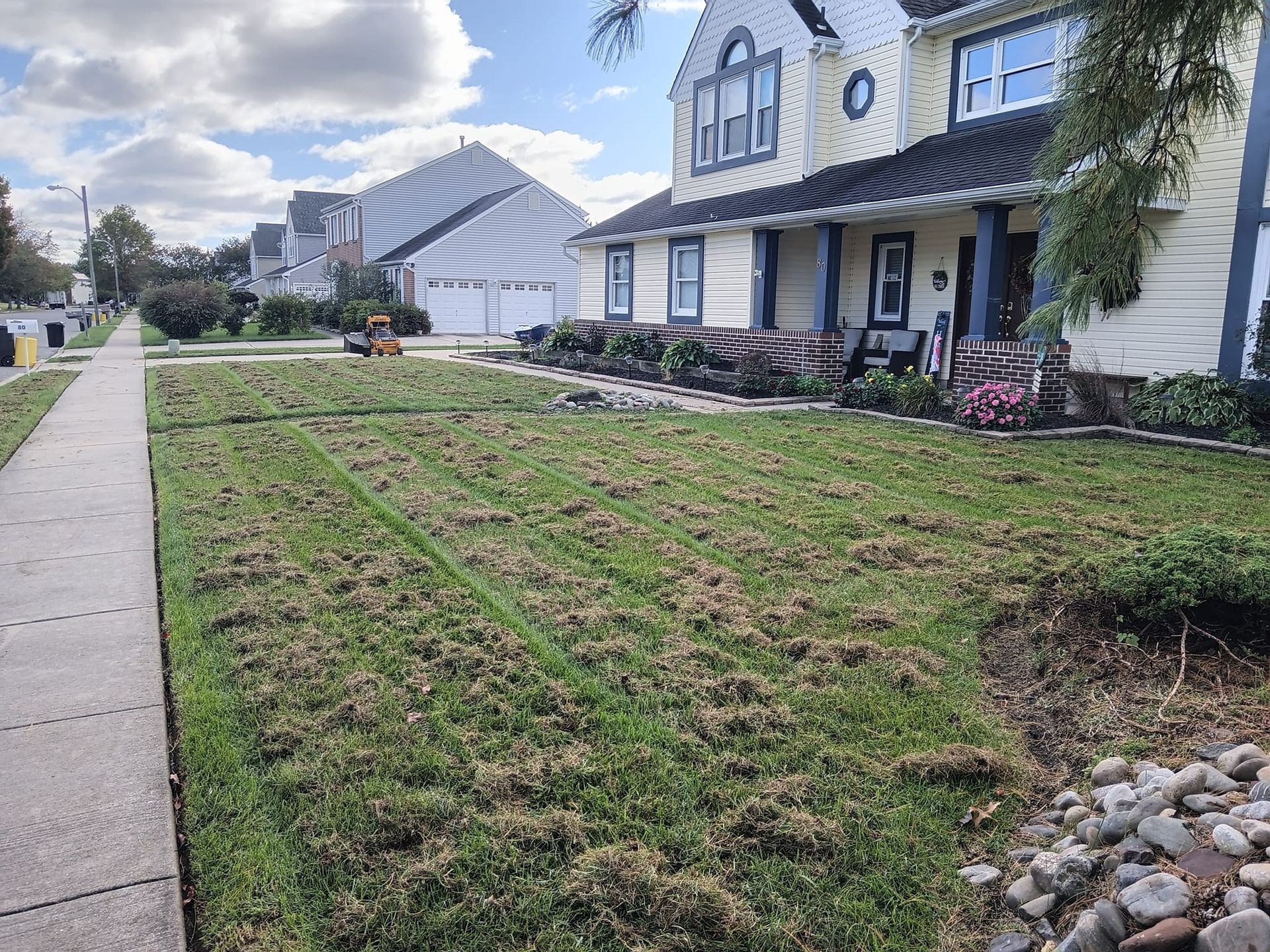 A large white house with a lush green lawn in front of it.