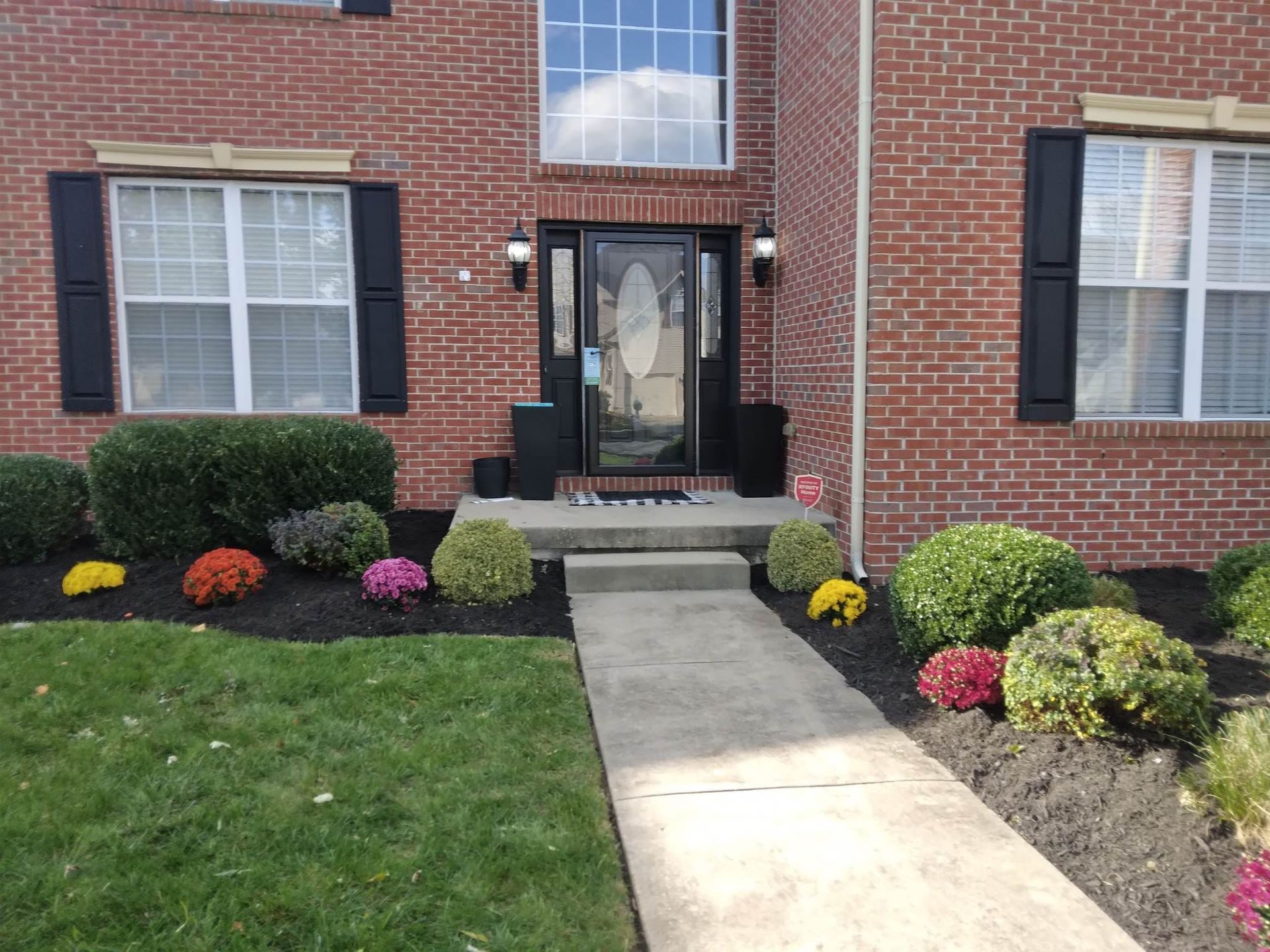 A brick house with a walkway leading to the front door