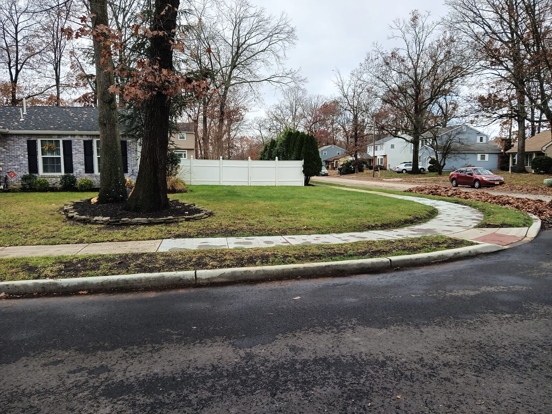 A brick house sits on the corner of a residential street