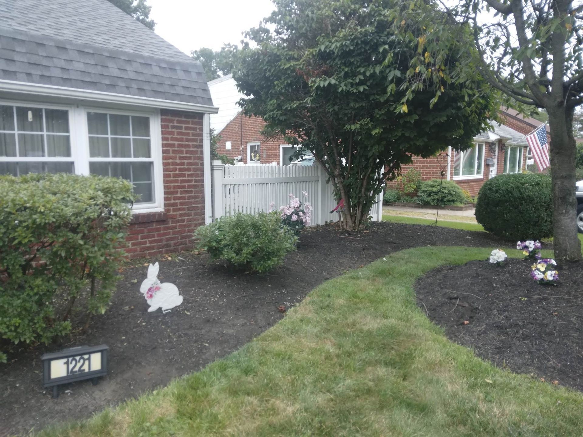 A brick house with a white fence 