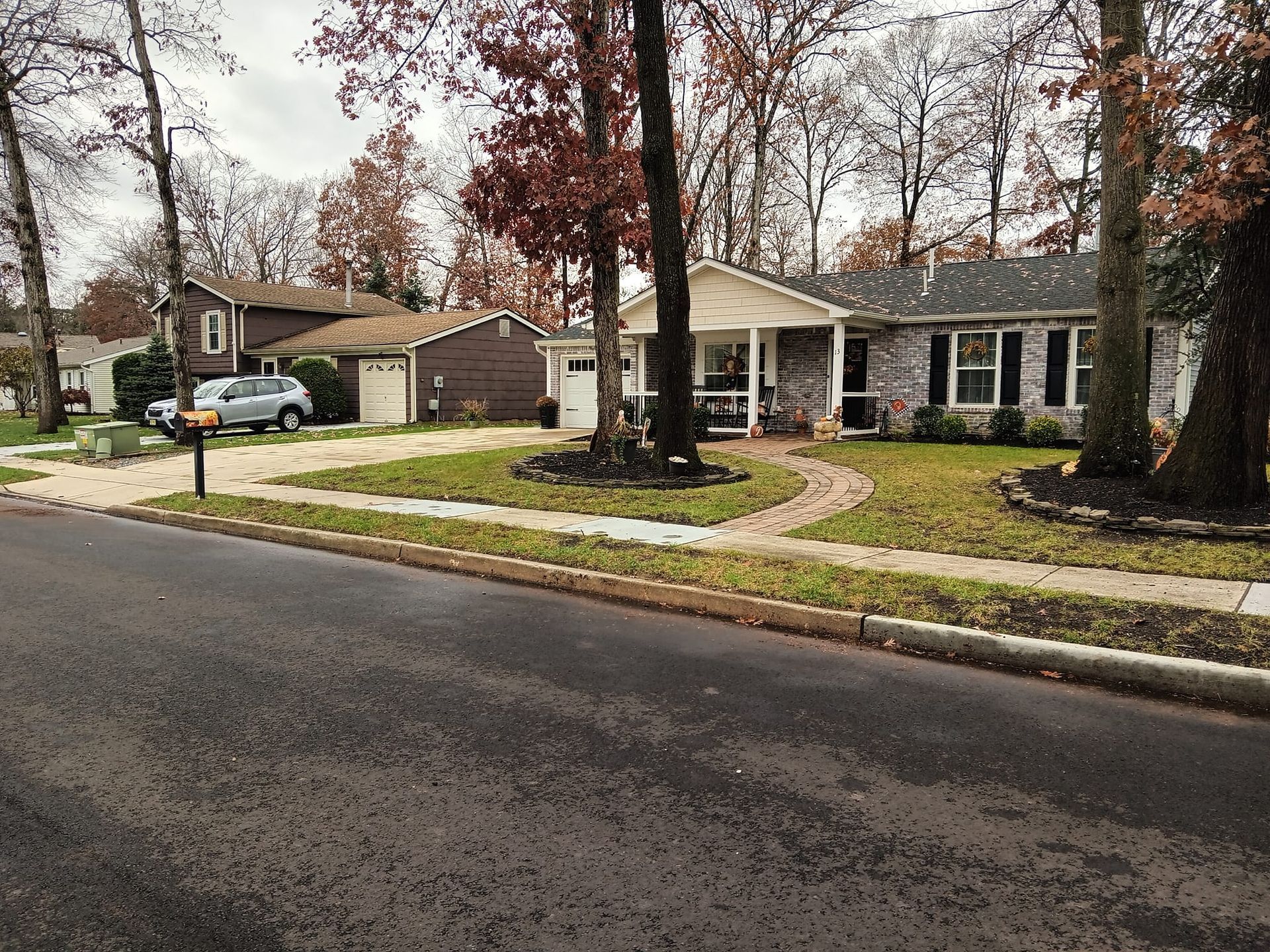 A house with a car parked in front of it and a mailbox on the side of the road.