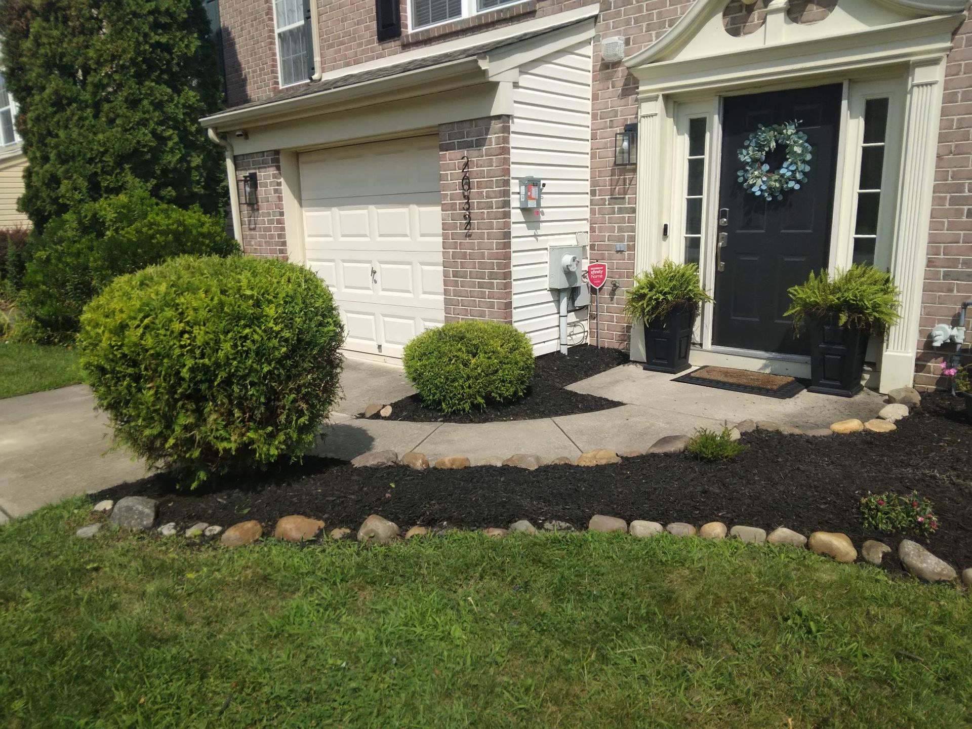 A house with a black door and a wreath on the front door.