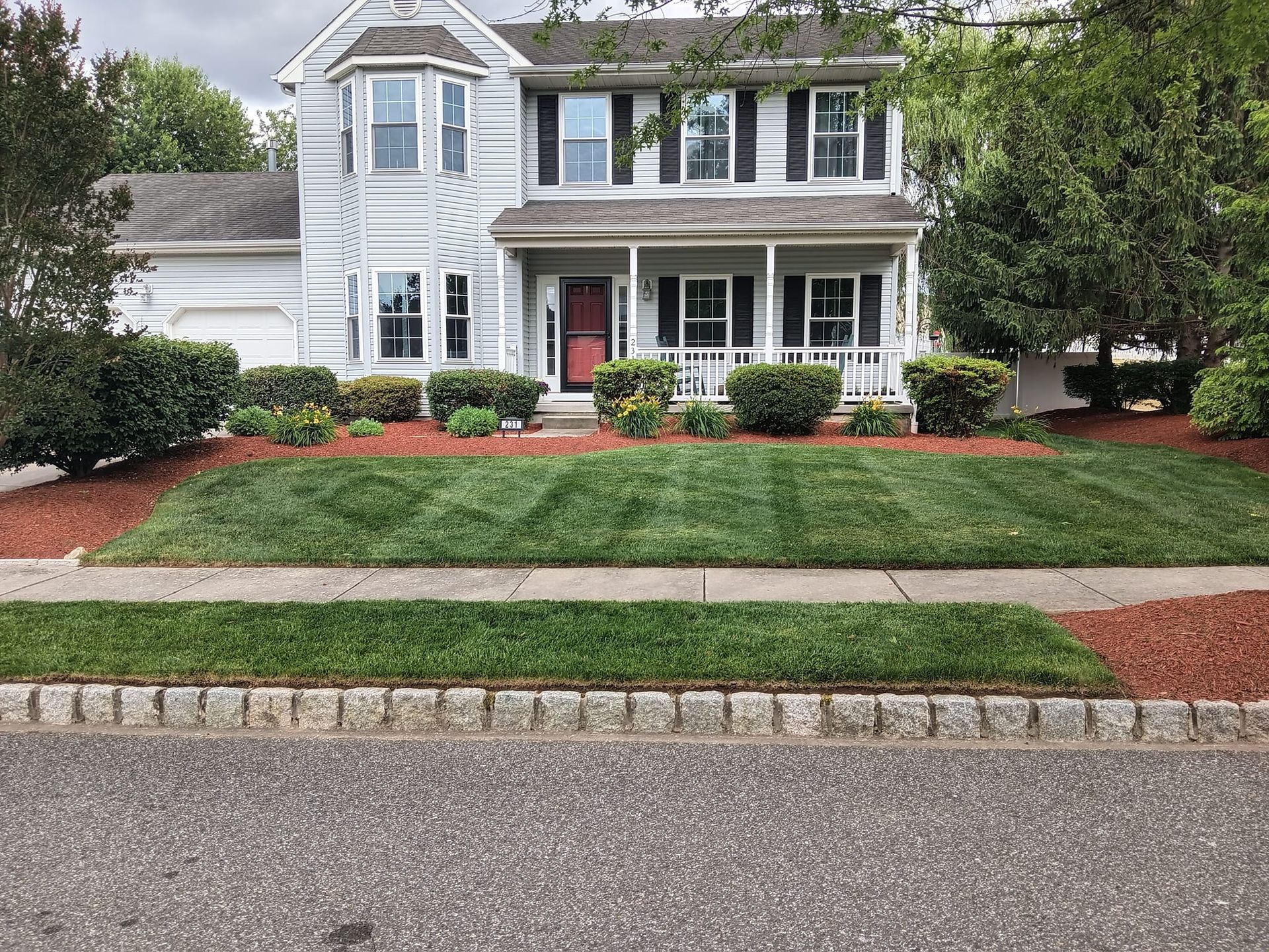 A large white house with a large lawn in front of it.