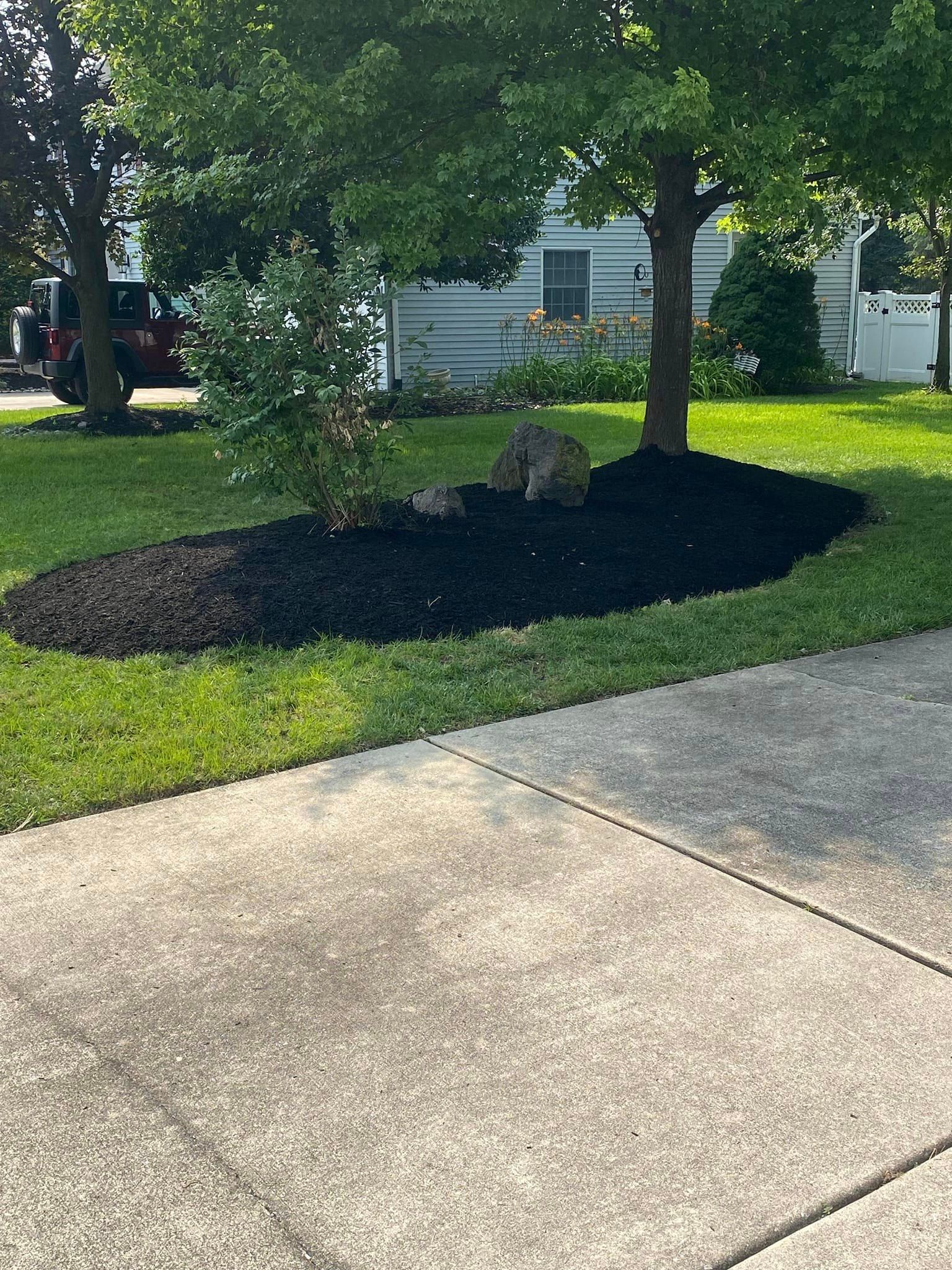 There is a large rock in the middle of the yard.