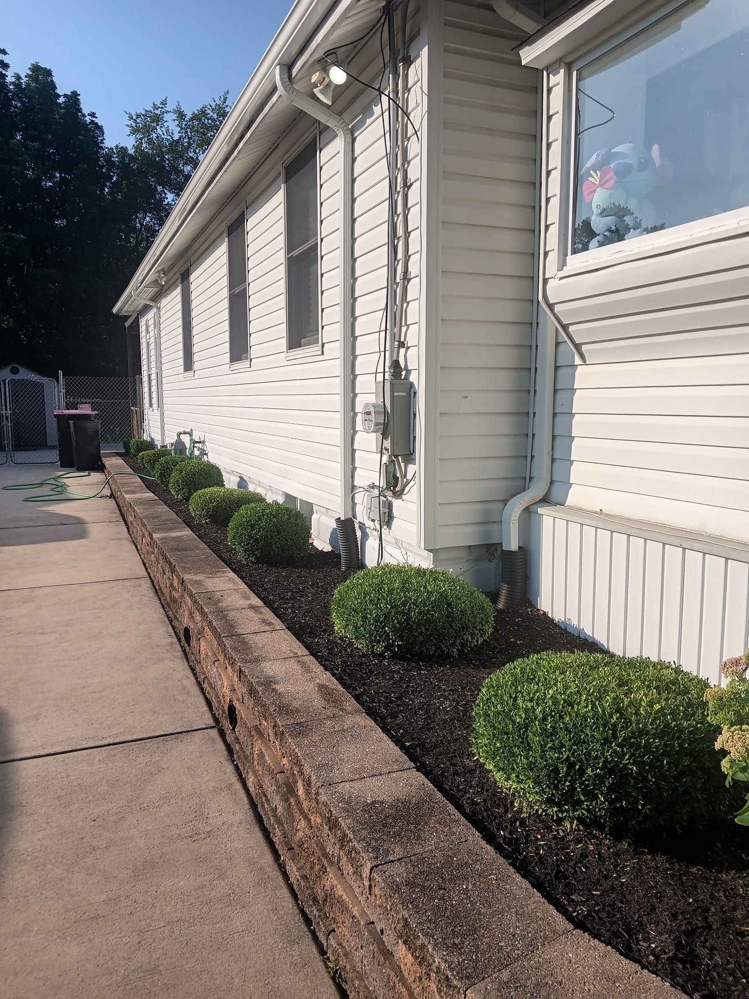 A white house with a concrete walkway leading to it.