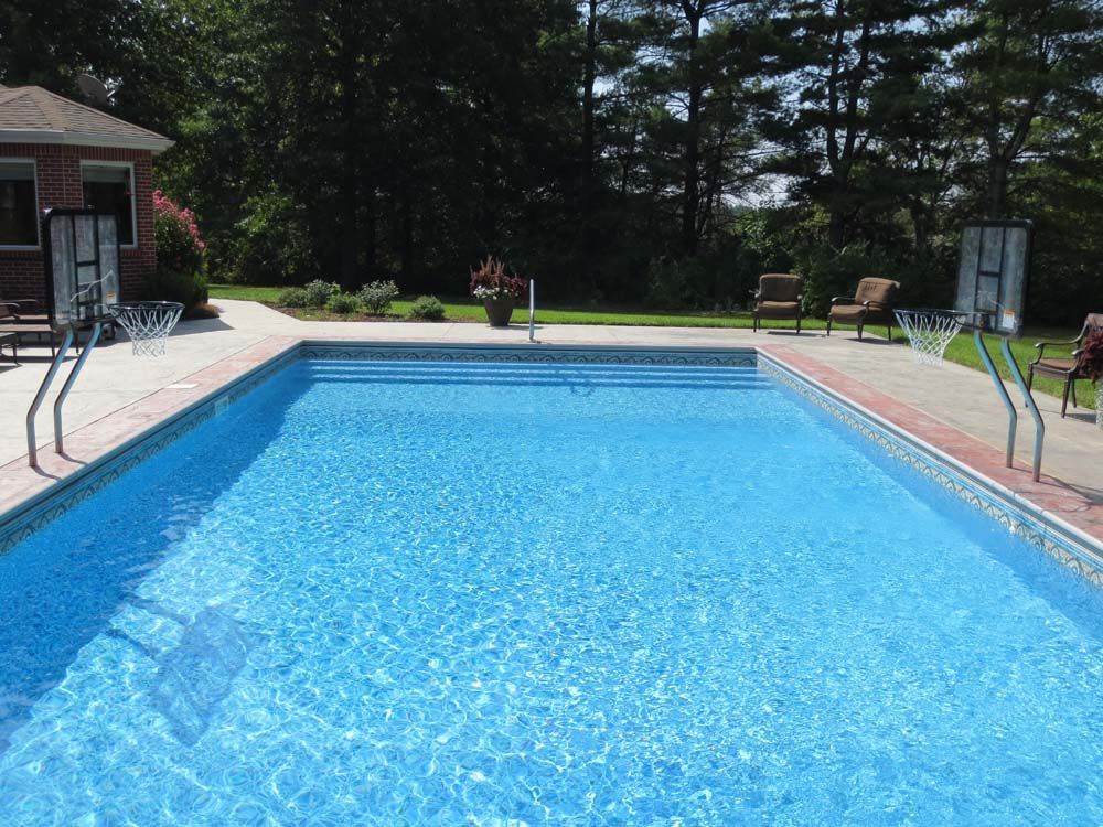 A large swimming pool with a basketball hoop in the background