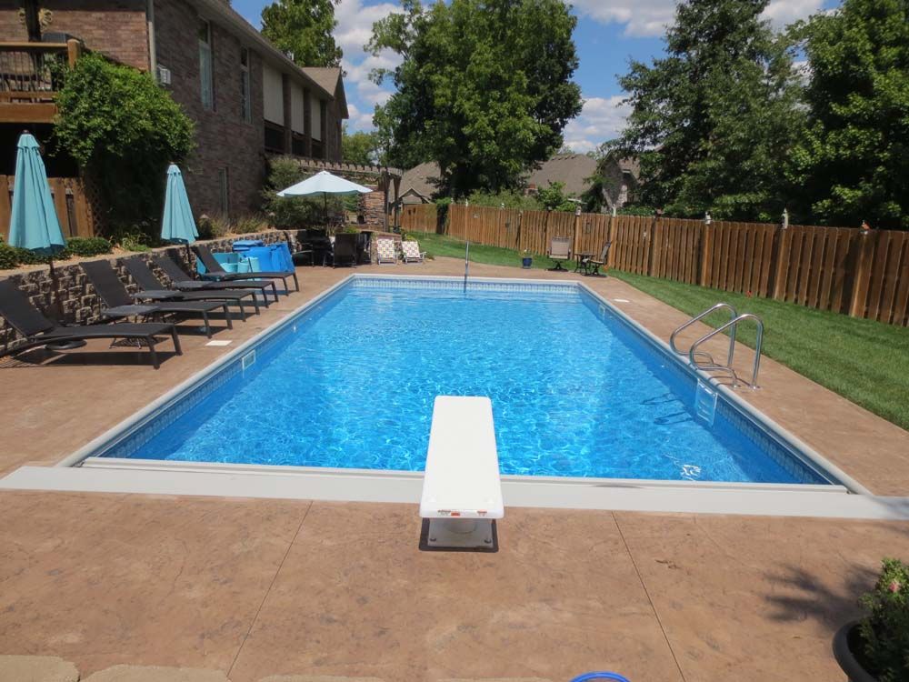 A large swimming pool with a diving board in the middle