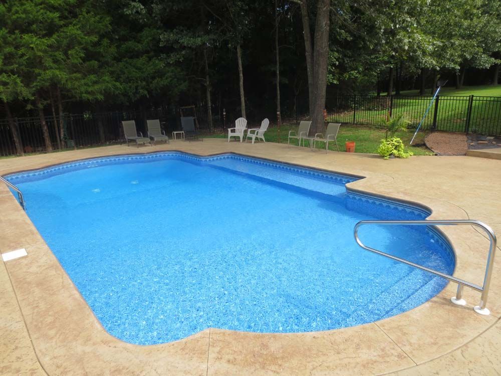 A large swimming pool surrounded by chairs and trees