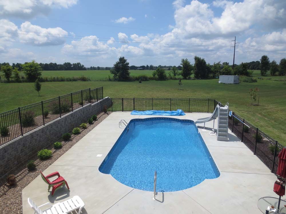 An aerial view of a large swimming pool surrounded by a fence.