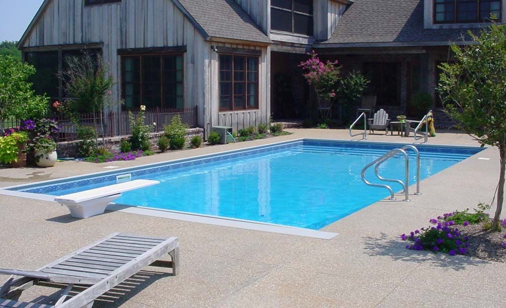 A large swimming pool in front of a house