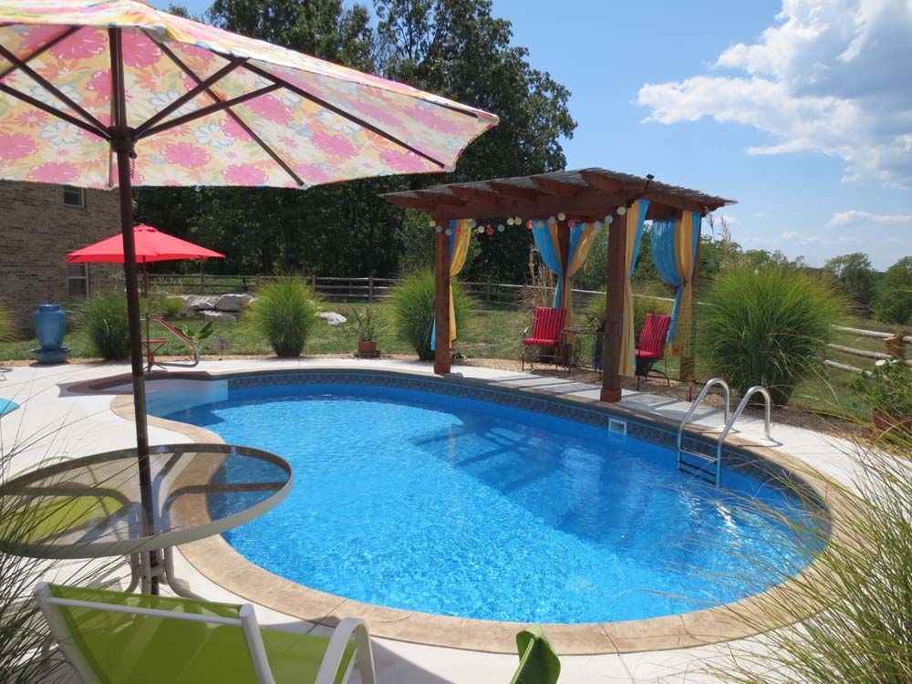 A large swimming pool with umbrellas and chairs around it