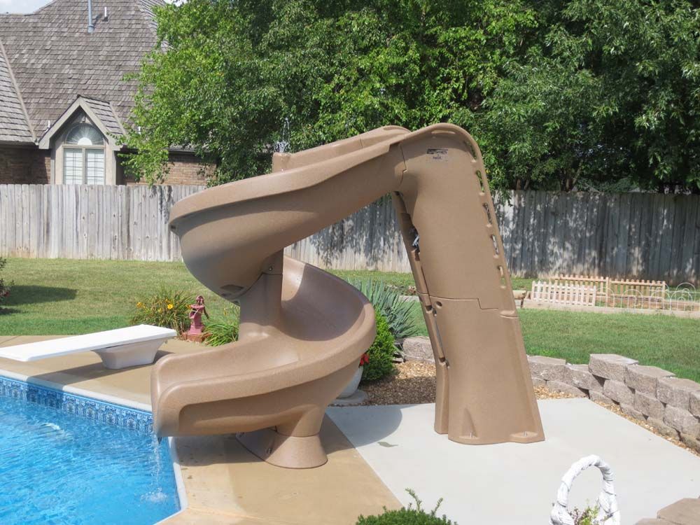 A brown water slide is next to a swimming pool