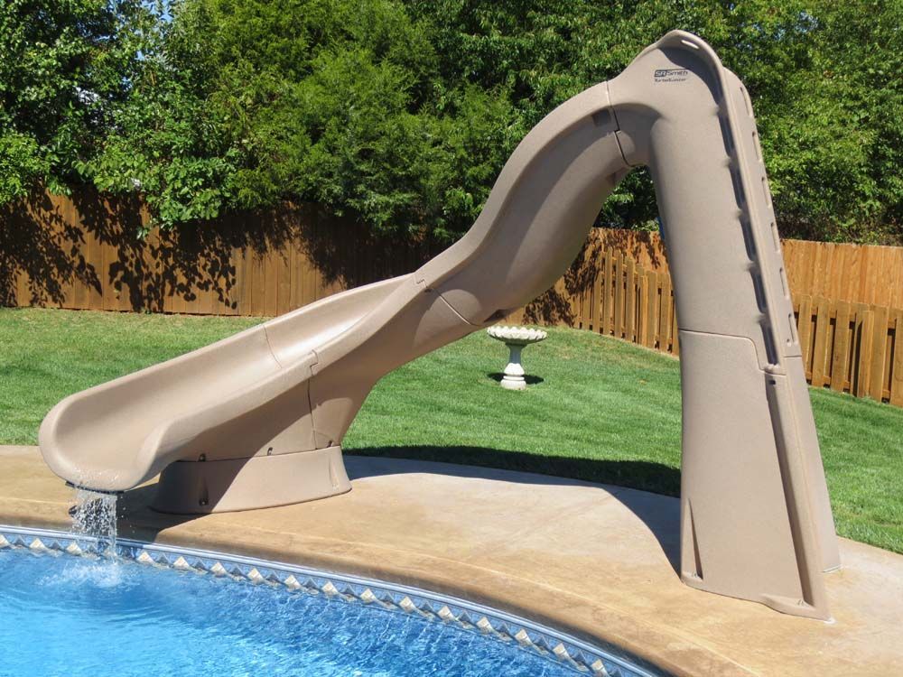 A brown slide is sitting next to a swimming pool
