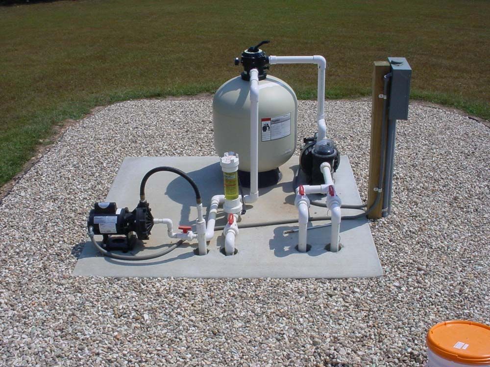 A swimming pool filter is sitting on top of a concrete platform