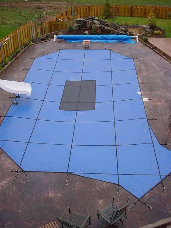 An aerial view of a swimming pool with a blue cover