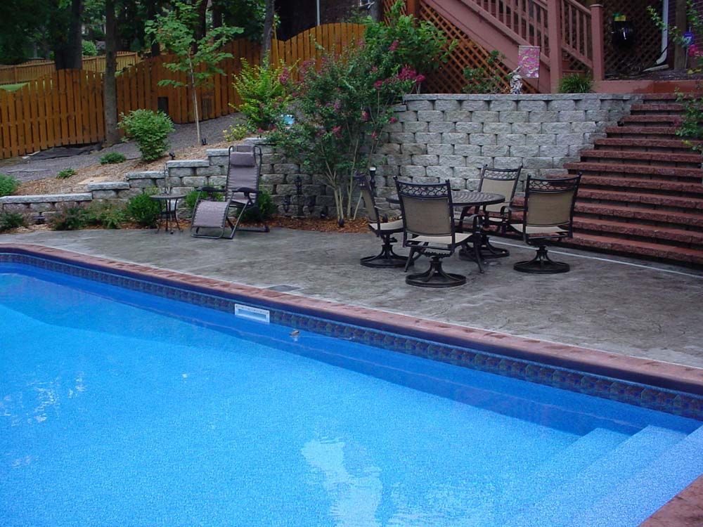A swimming pool with a table and chairs around it