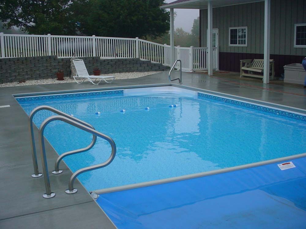 A large swimming pool with a white fence around it