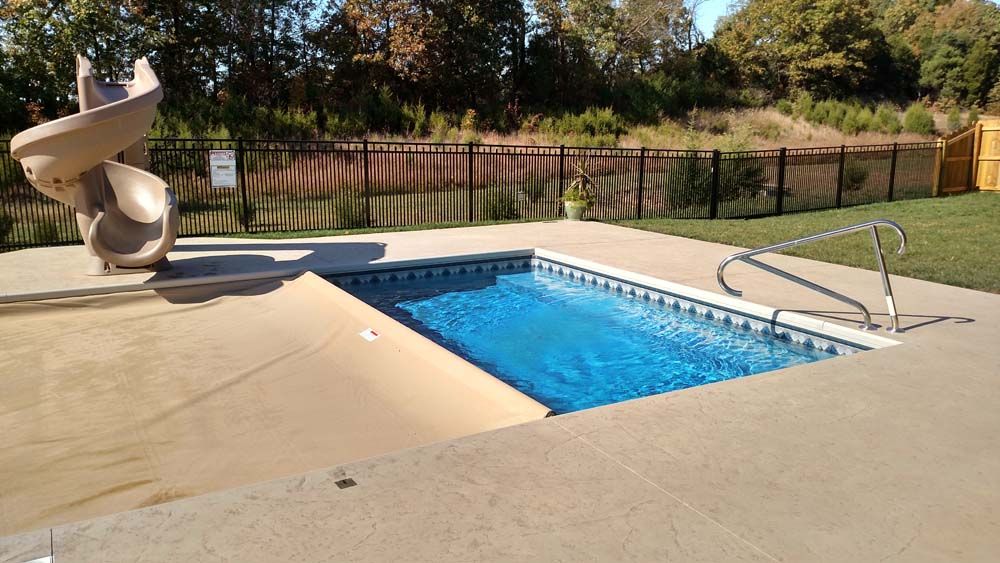 A small swimming pool with a slide next to it