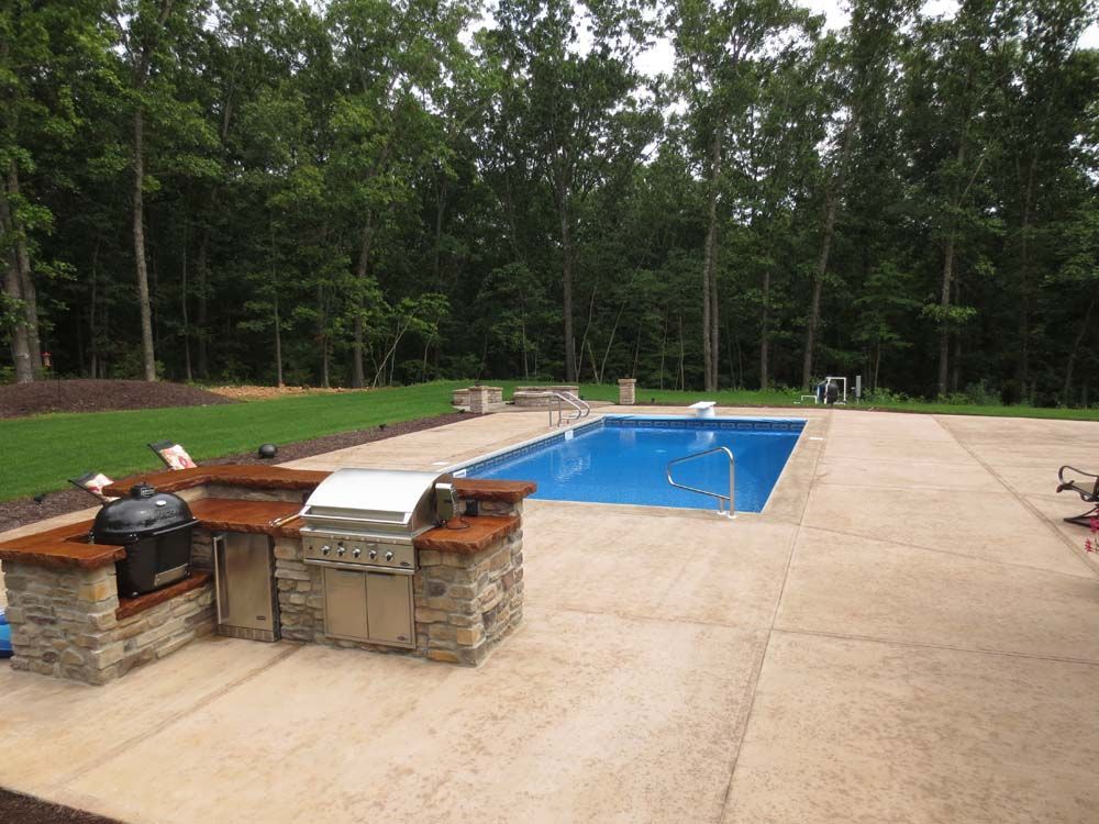 A large swimming pool with a grill in the middle of it