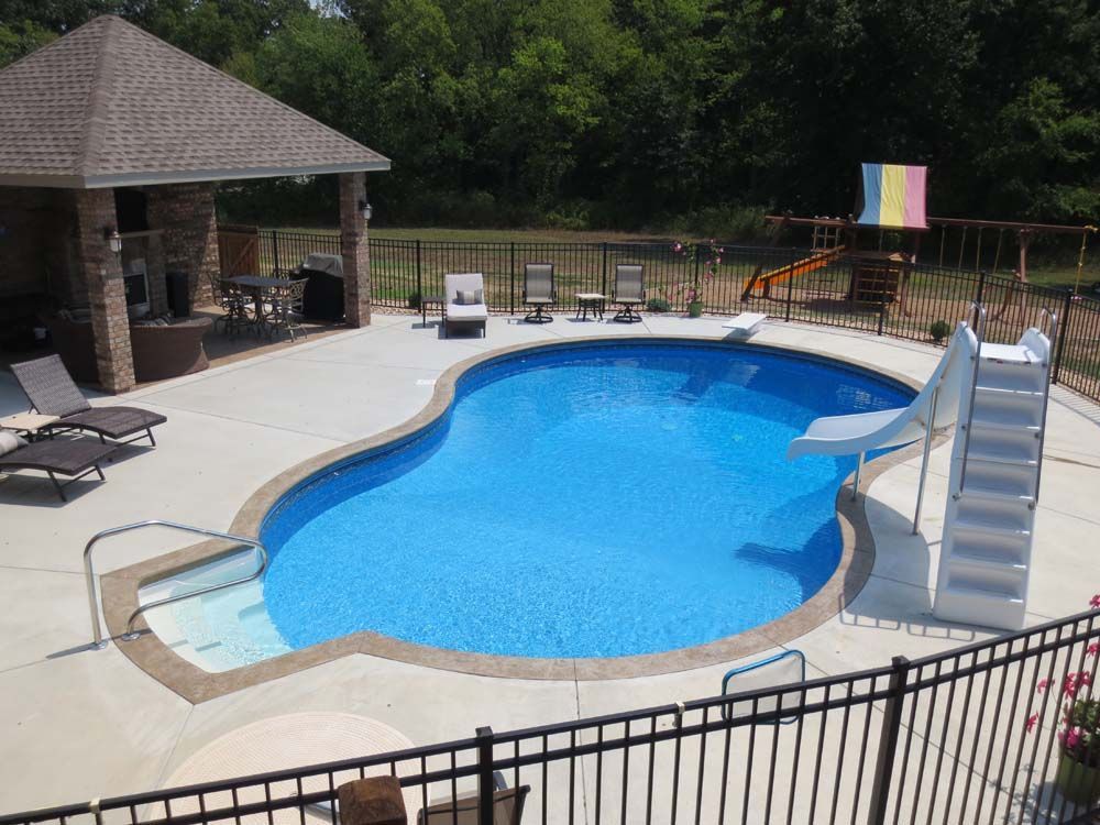 A large swimming pool with a slide and stairs