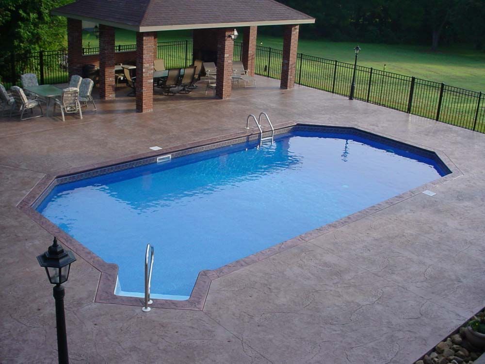 A large swimming pool with a gazebo in the background