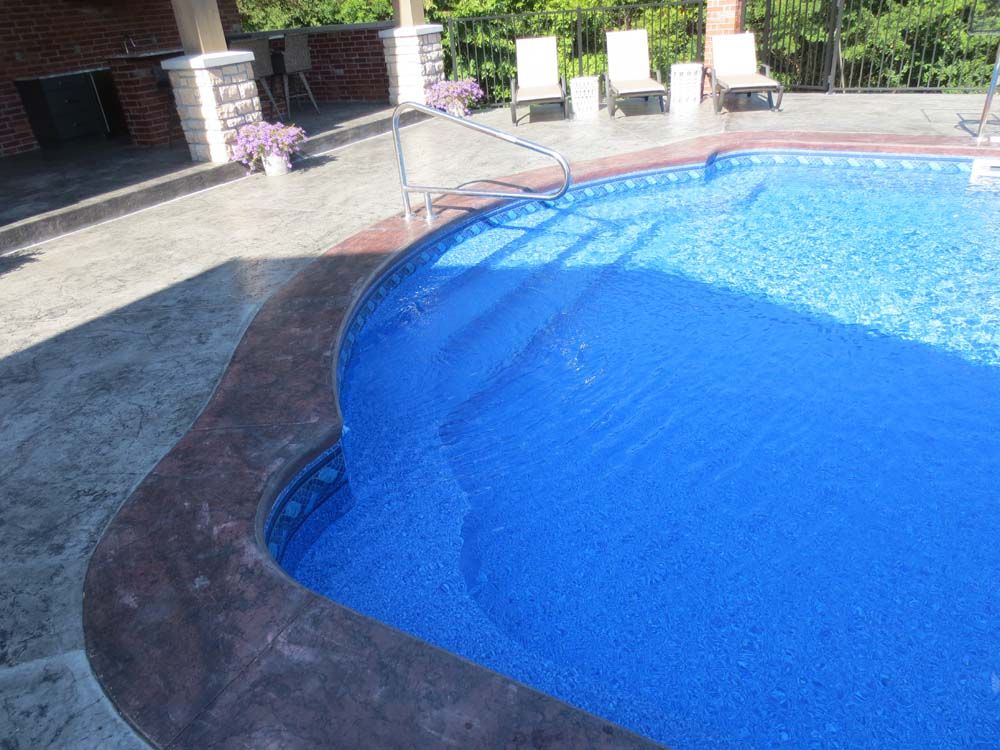 A large blue swimming pool with chairs around it