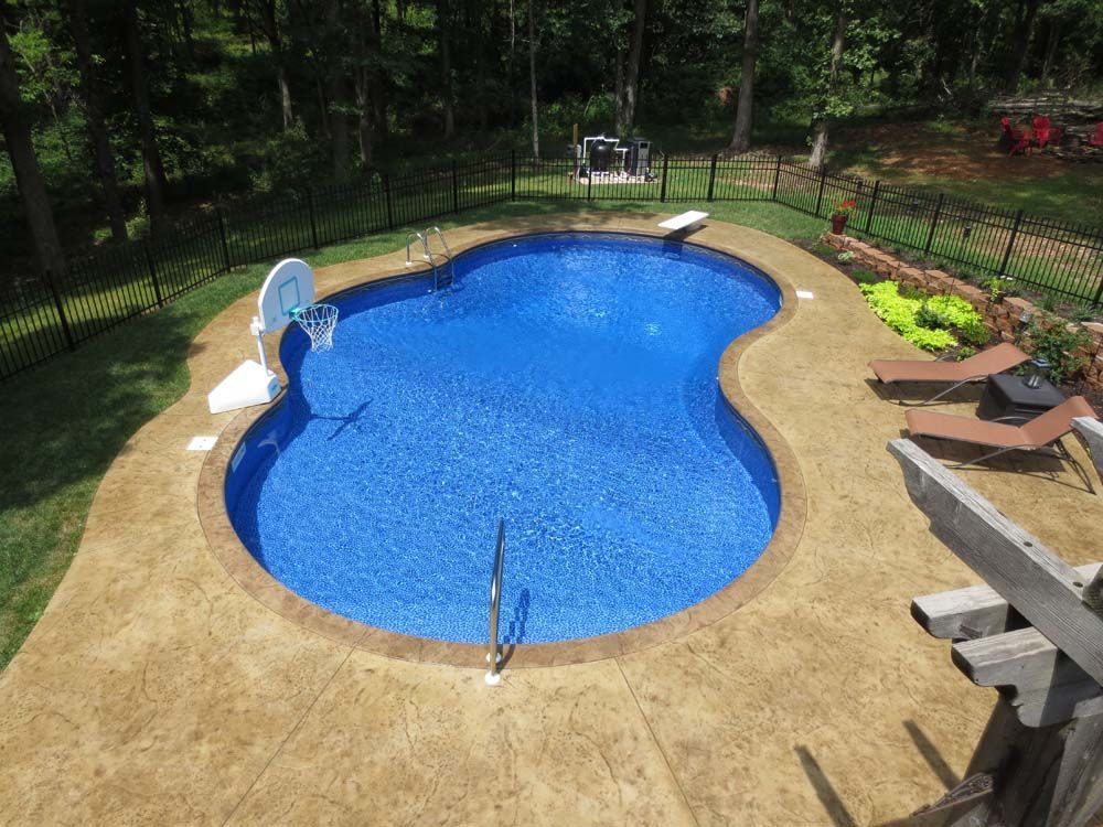 An aerial view of a large swimming pool with a basketball hoop in the middle.