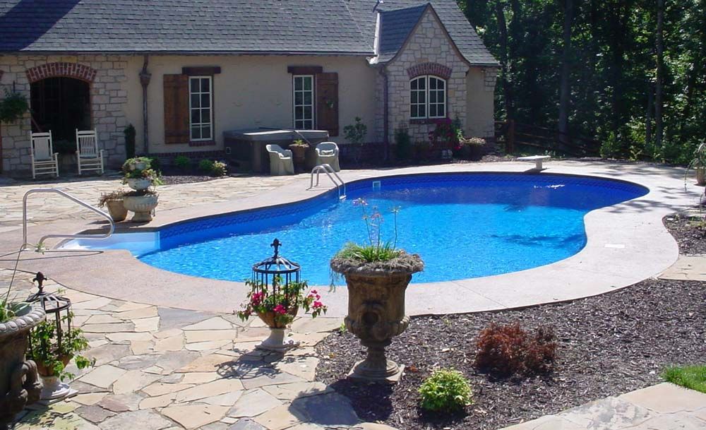 A house with a large swimming pool in front of it