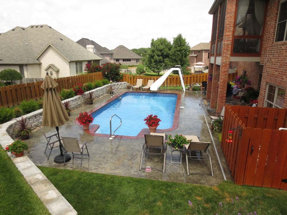 A large swimming pool is surrounded by chairs and umbrellas