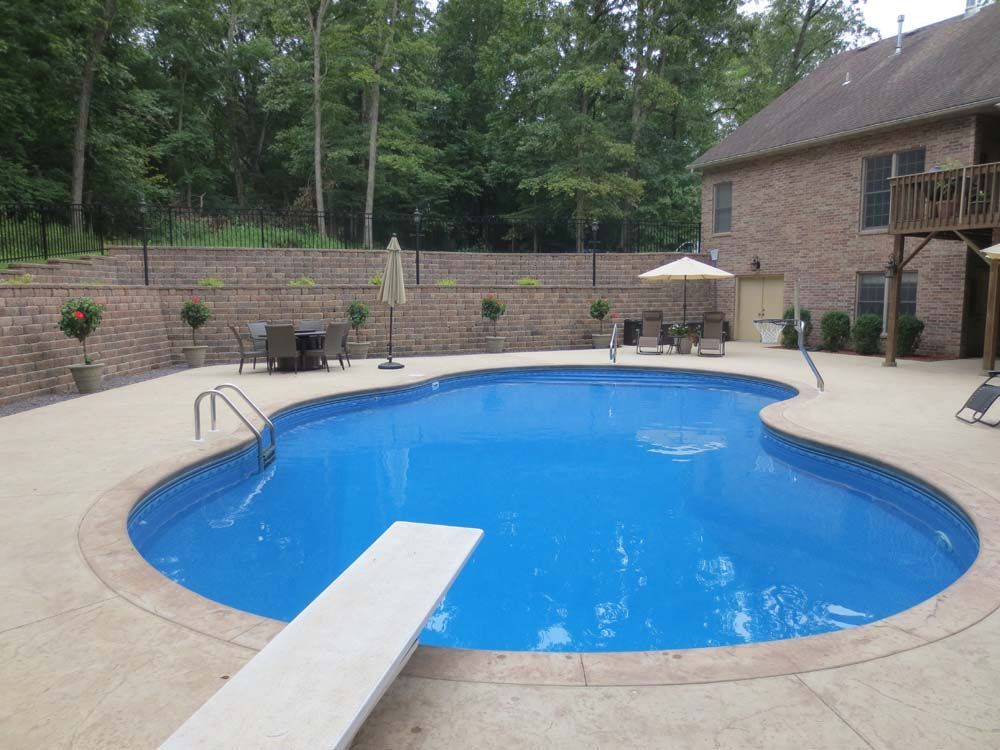 A large swimming pool with a diving board in the middle of it