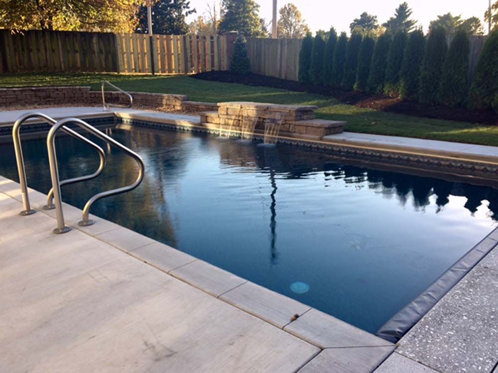 A large swimming pool with a fence in the background
