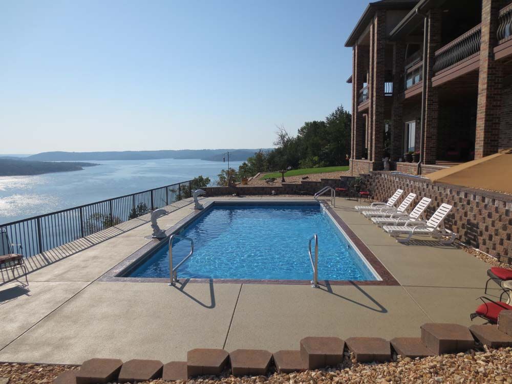 A large swimming pool with a view of a lake