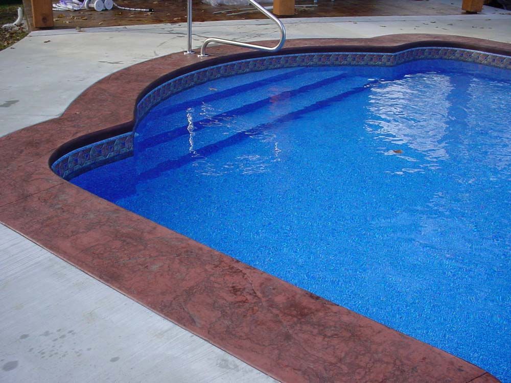A swimming pool with blue tiles and stairs