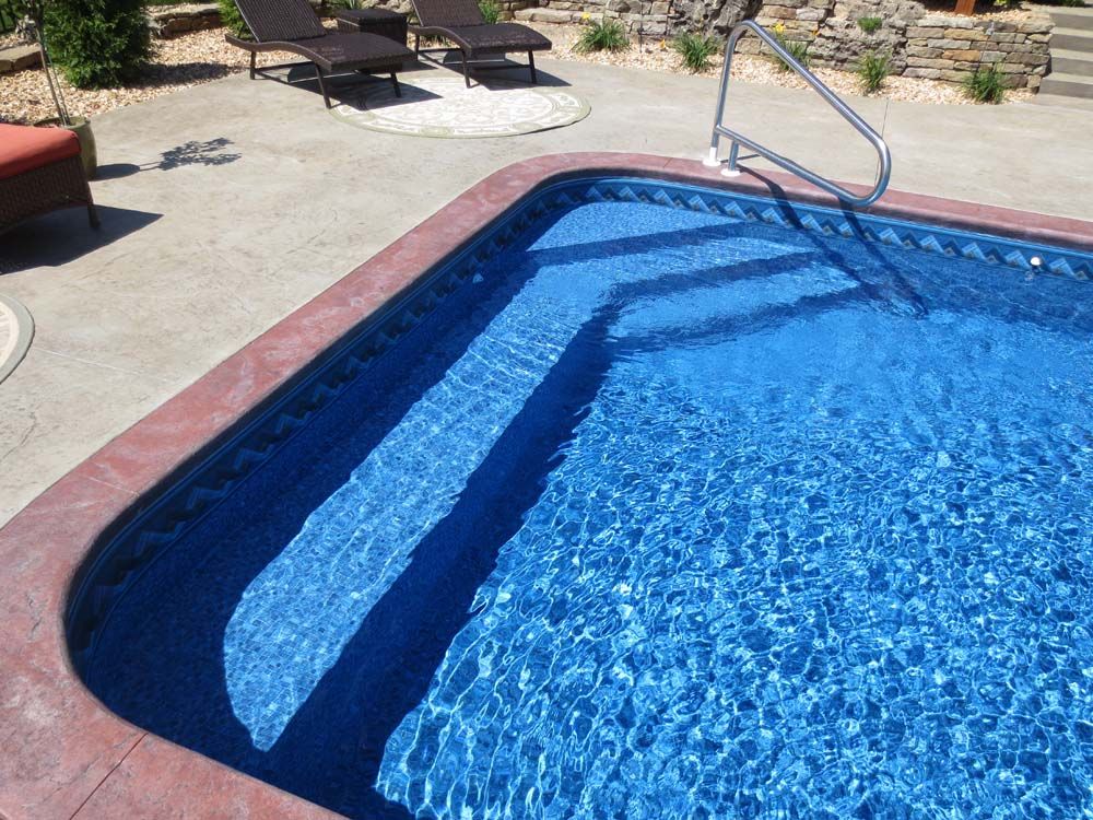 A large swimming pool with stairs leading to it