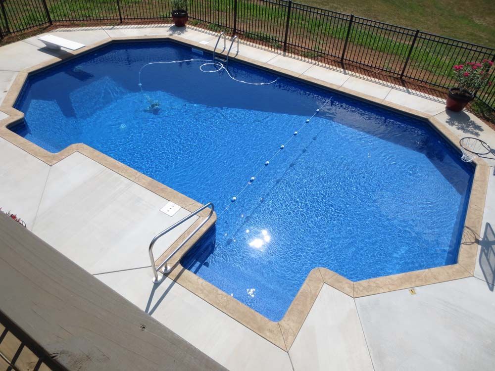 An aerial view of a large swimming pool surrounded by a fence