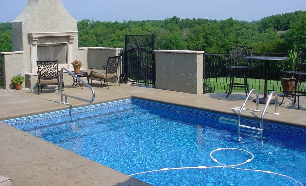A large swimming pool with a fireplace in the background