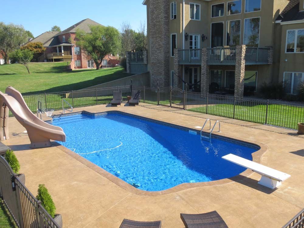 A large swimming pool with a slide and a diving board