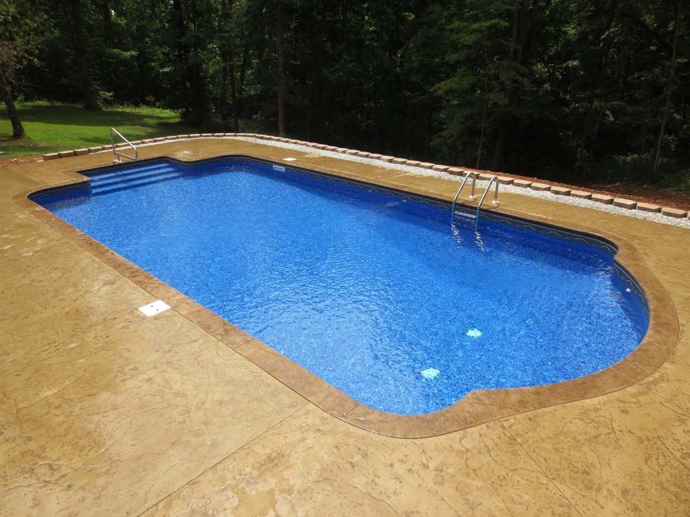 A large blue swimming pool is sitting on top of a concrete deck.