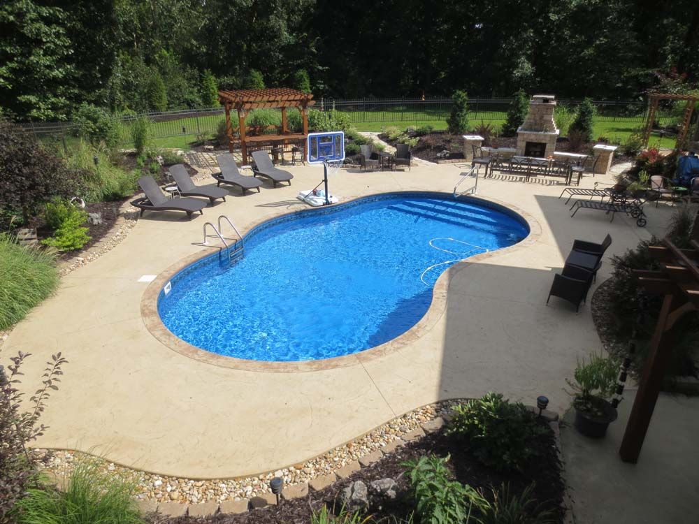 A large swimming pool surrounded by chairs and a basketball hoop